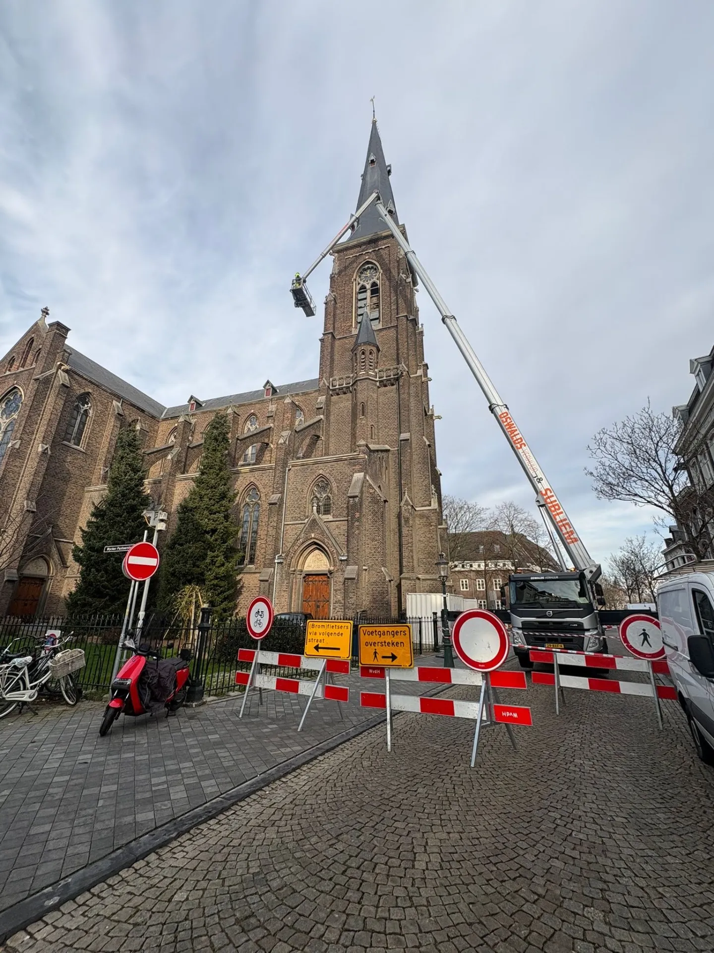 Vrachtautohoogwerker van Oswalds Verhuur bij restauratiewerk aan een kerktoren