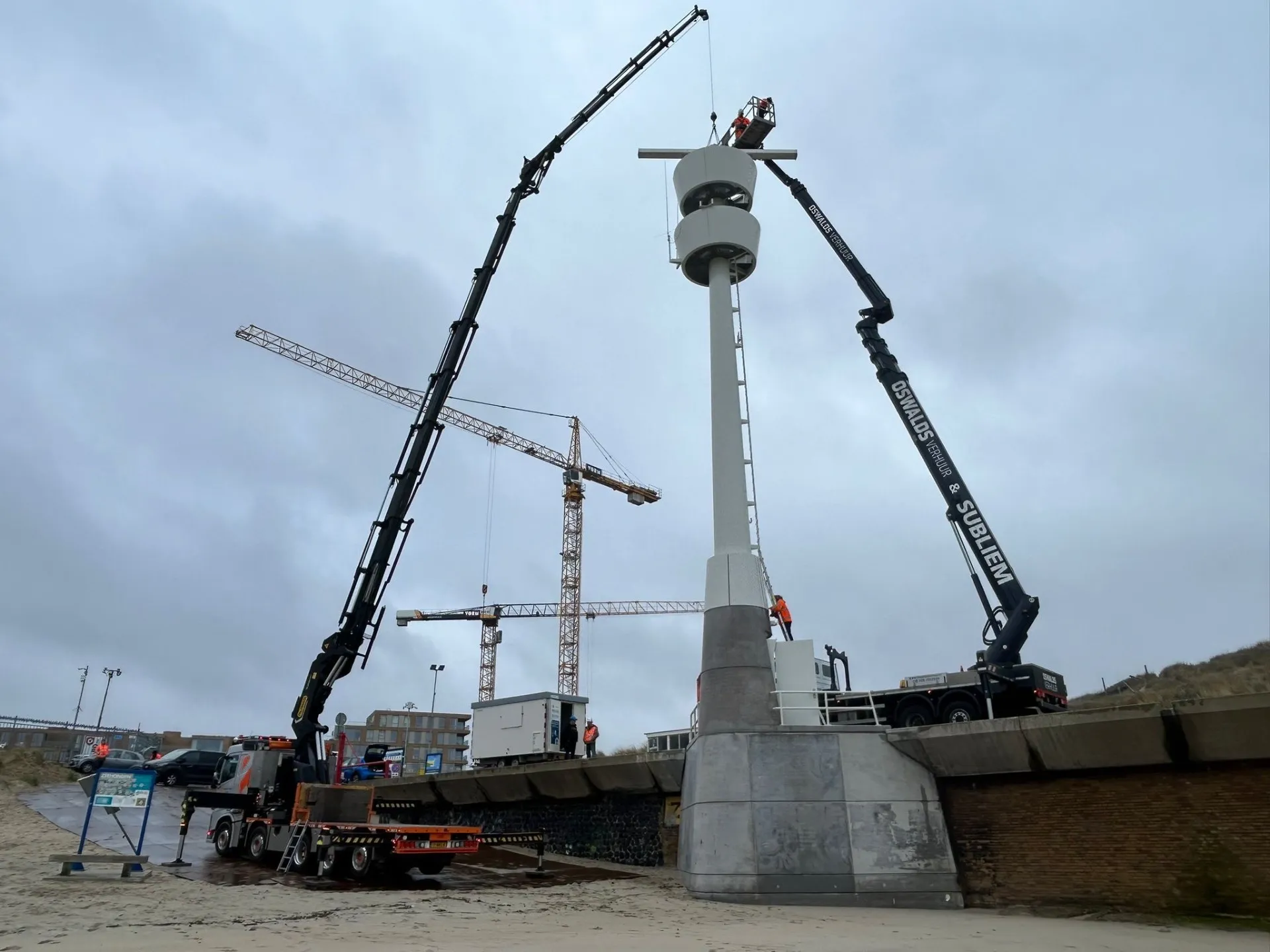 Twee vrachtwagenhoogwerkers bij kustinstallatie